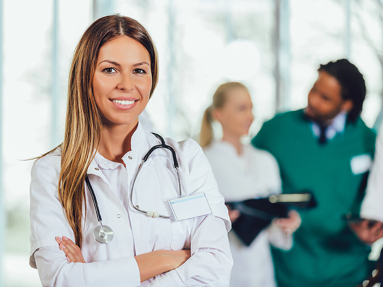 Ärztin auf einem Krankenhausflur, die lächelnd in die Kamera schaut | Foto: ©Mediteraneo – stock.adobe.com