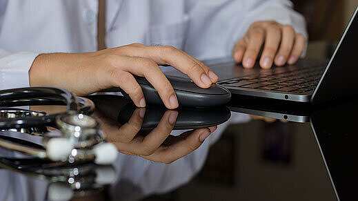 Arzt Hand mit drahtloser Maus arbeiten mit Laptop-Computer im medizinischen Büro | Foto: ©NIKCOA – stock.adobe.com