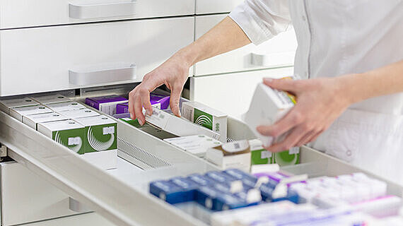 Apothekerin hält Medikamentenschachtel und Kapselpackung in einer Drogerie. | Foto: ©Aliaksandr – stock.adobe.com